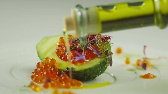 在豪华餐厅用牛油果和橄榄油装饰红鲑鱼鱼子酱