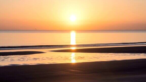 在新西兰野生自然的海洋海滩上日落时的橙色天空