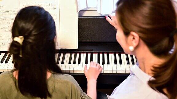 母亲和女儿在弹钢琴