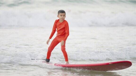 4K亚洲小男孩在海里冲浪的肖像