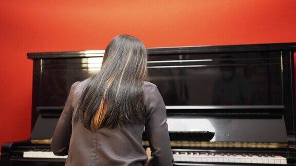 年轻女子在她的工作室里弹钢琴