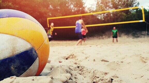 一群朋友在玩沙滩排球球在沙子的特写