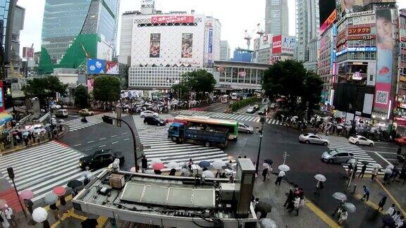 日本东京涩谷人们撑着雨伞穿过著名的对角线十字路口的4K时间