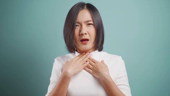 一名亚洲妇女喉咙痛孤立地站在蓝色背景下卫生保健4k的视频