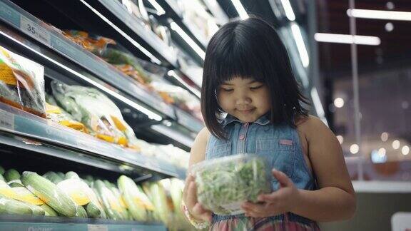 小女孩在超市挑选蔬菜