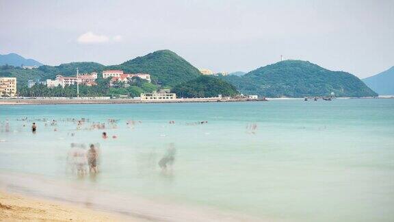 日落三亚著名的大东海拥挤的海滩全景4k时间推移海南岛中国