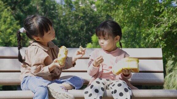 在公园野餐时孩子们吃面包