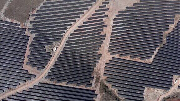 无人机俯瞰光伏太阳能发电公园一排排电池板丘陵阳光明媚