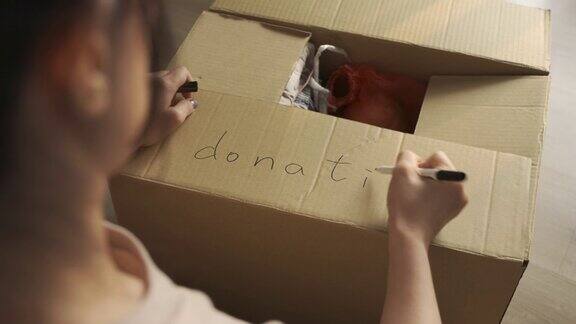 亚洲女性志愿者把衣服和食物放在捐赠箱里