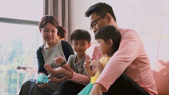一个微笑的亚洲家庭用储蓄罐存钱