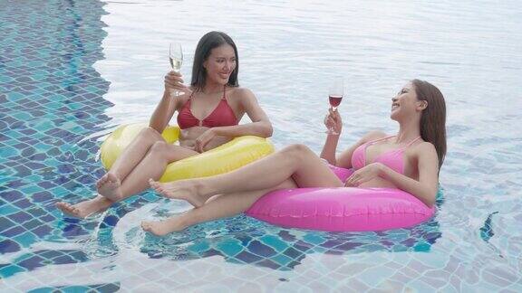 一群朋友在他们的私人泳池别墅里放松一起享用香槟