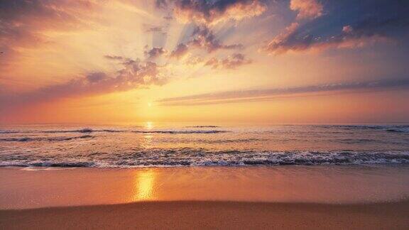 热带海洋的日出燃烧的天空闪耀的金色海浪拍打着海滩