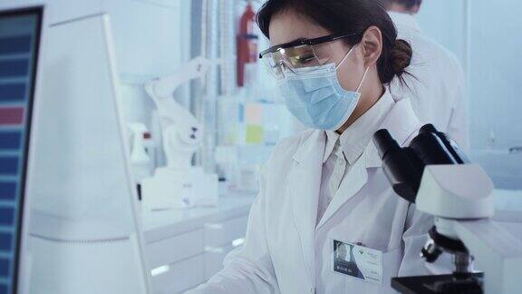 使用显微镜工作的女性亚洲科学家背景研究伙伴