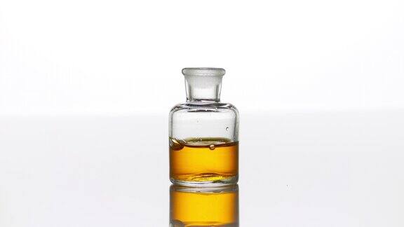 摩洛哥坚果油滴入带有黄色液体的透明瓶中