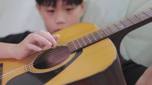亚洲男孩弹奏原声吉他