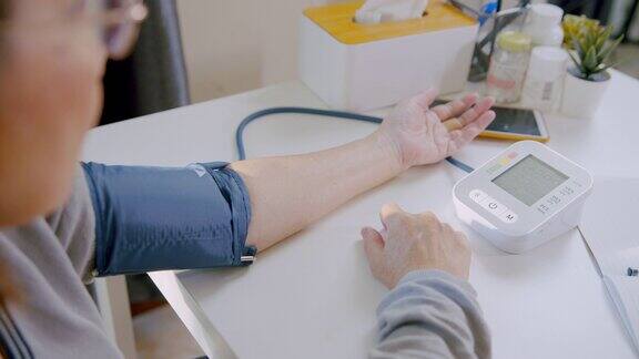 老年妇女使用医疗器械在家检查血压计和心率