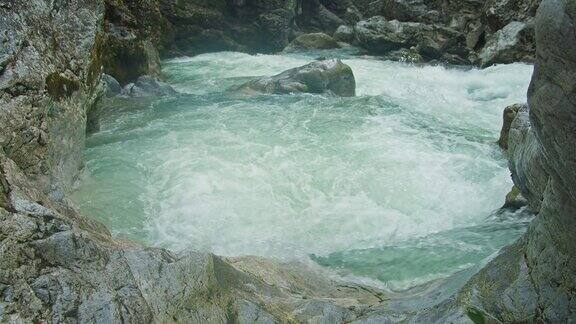 冰冷的山河带着清澈的冰川水在岩石峡谷中流淌阿尔卑斯山春天的自然景观