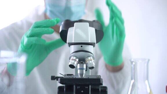 把载玻片放在显微镜下的科学家