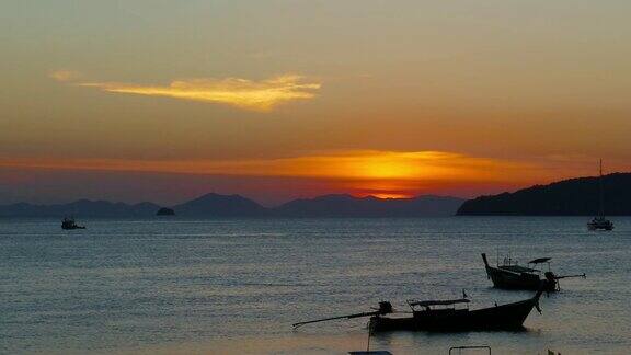 日落时海上有长尾船泰国
