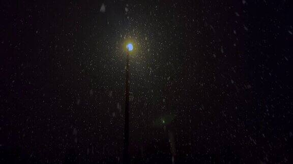 夜暴雪雪花映衬着一盏灯的背景