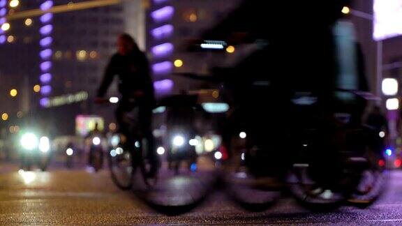 很多骑自行车的人在晚上骑自行车自行车游行在模糊的灯光城市街道时间推移一群骑自行车的人自行车交通概念运动健康的生活方式明亮的强光照射低角度的观点