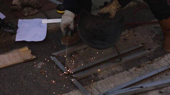 一名中年男性工人正在使用切割机和焊机