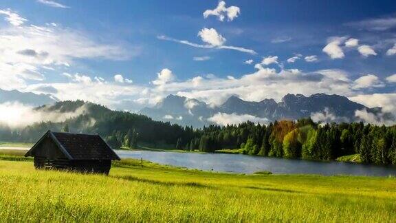 时间流逝的雾漂浮在孤独的房子在草地在美丽的早晨日出在山上湖Geroldsee在巴伐利亚阿尔卑斯德国