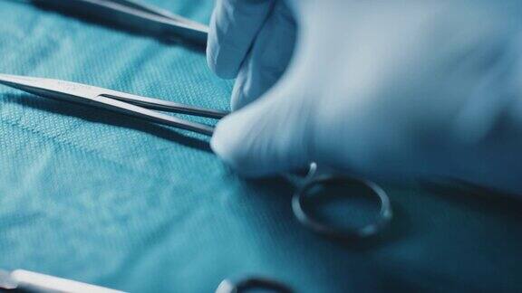 外科医生从医用托盘中取缝线的双手