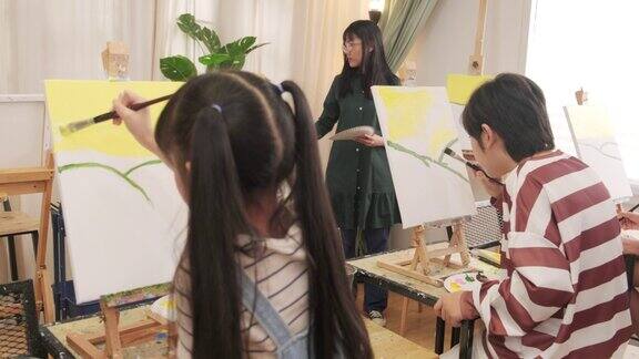 一群孩子正在美术课上用丙烯颜料画画