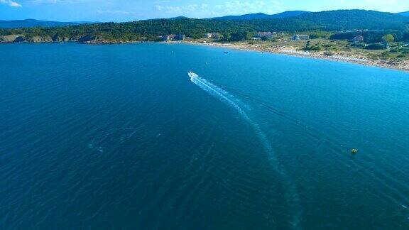 鸟瞰图无人机跟随一艘船或游艇在美丽的蓝色海水