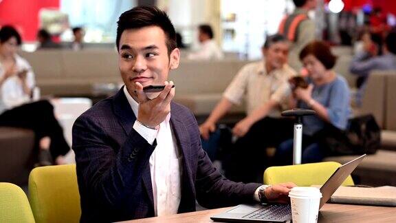 微笑的男性企业家在机场使用手机