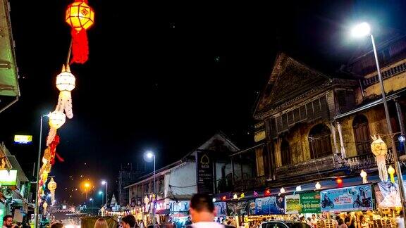 泰国彝蓬节上装饰着灯笼的风景道路上的夜间交通延时视频