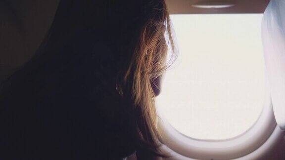 亚洲女游客在飞机上打开窗户