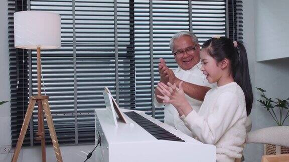 爷爷在家教小孙女弹钢琴