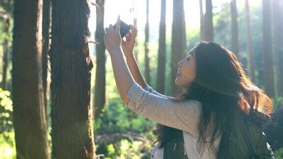 在森林里用手机拍照的妇女