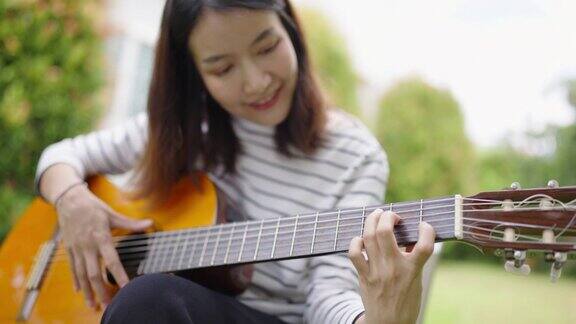 亚洲女人在院子里教弹吉他