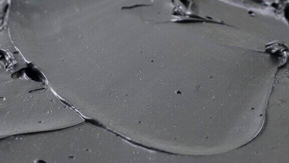 黑色粘土和泥面膜光滑细腻的纹理涂抹圈旋转近