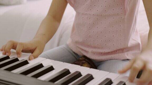 一个亚洲女孩正在做一个学习弹奏电子钢琴的活动练习音乐会给你很好的情感技巧;放松;心理健康心情好