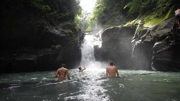 男女游客在瀑布中沐浴享受淡水