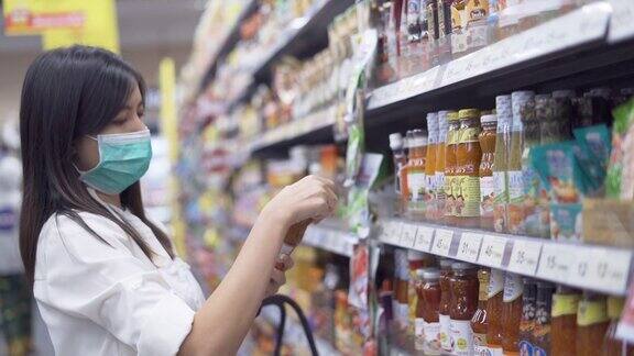 一名戴着医用防护口罩的妇女正在超市选购商品