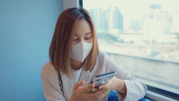 年轻的商业人士在电动汽车上使用手机时戴上医用口罩