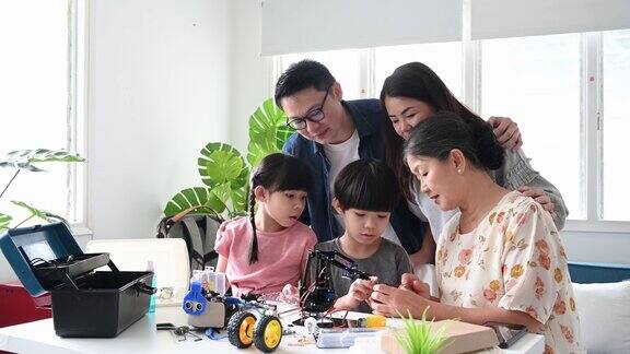三代亚洲华人家庭在家里一起制作机器人玩具