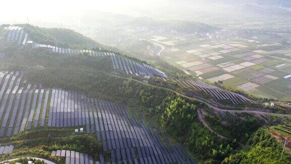 鸟瞰图山顶太阳能发电厂和山下的农场