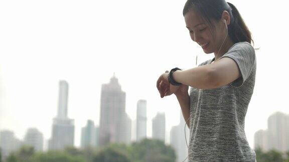 亚洲女性使用智能手表检查脉搏在锻炼