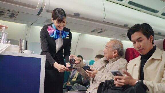 美丽的空姐提供饮料和零食给老乘客在飞机上