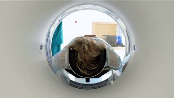 近距离拍摄的女性成熟的病人躺在一台CT扫描仪的桌子上电脑断层扫描仪对老年妇女的身体和大脑进行扫描医疗诊所的高科技设备4k