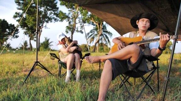 在帐篷前一起弹吉他、唱歌野营