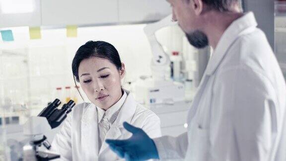 未来实验室亚洲女医生使用显微镜前景广阔