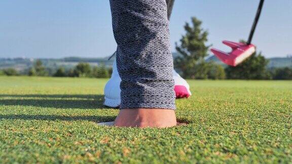 高尔夫球手把球推洞在绿色高尔夫球场天空的场景背景
