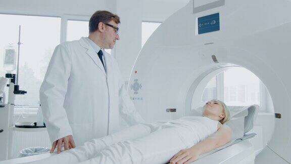 在医学实验室男性放射科控制MRI或CT扫描与女性患者进行程序高科技现代医疗设备提升相机拍摄
